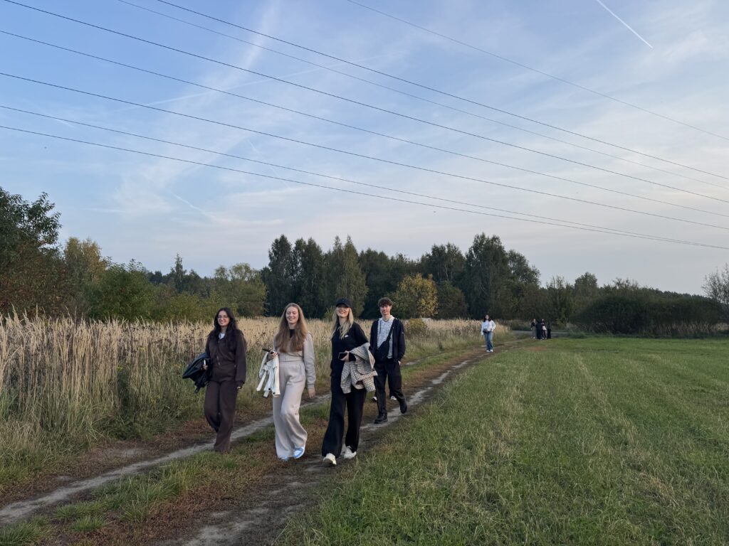 Studenci podczas spaceru wśród łąk
